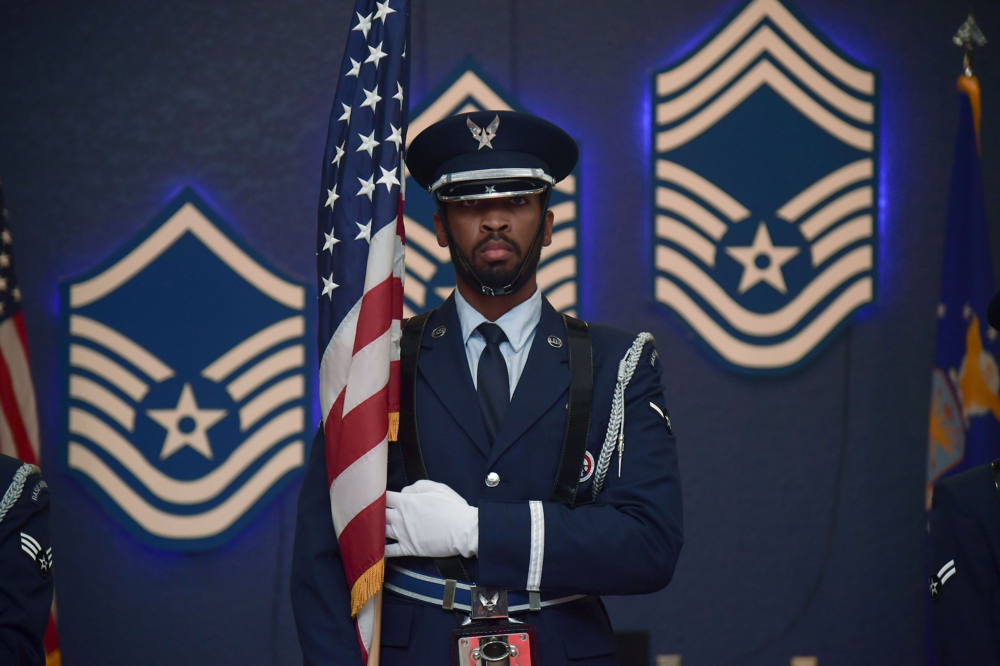 A man in military uniform holds the U.S. Flag