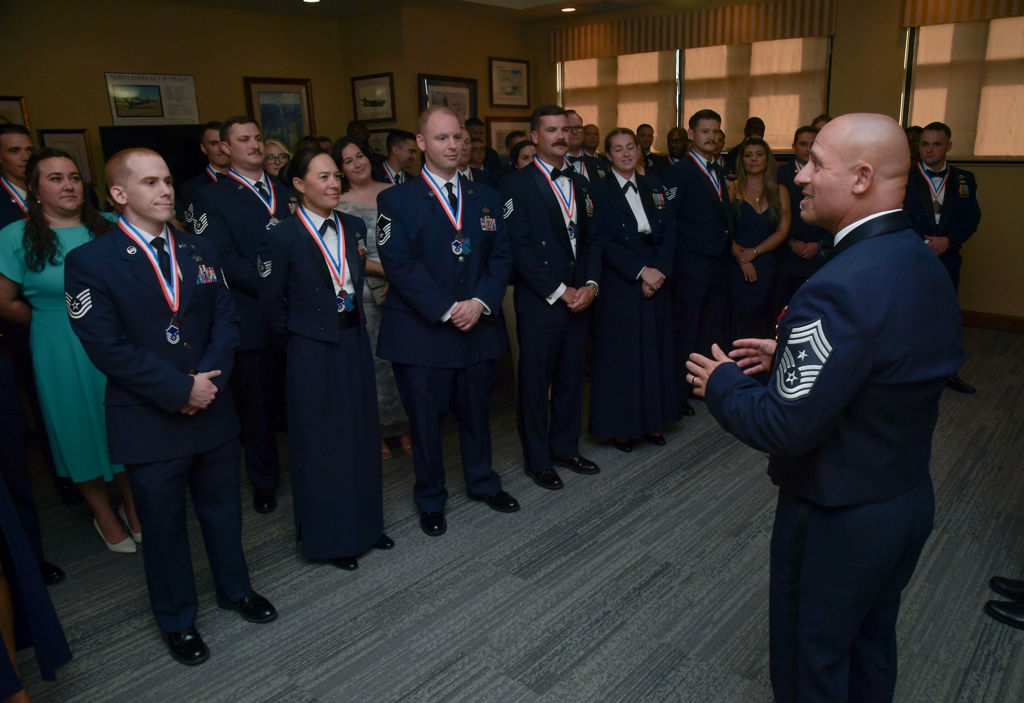 A man in military uniform speaks to a group of people
