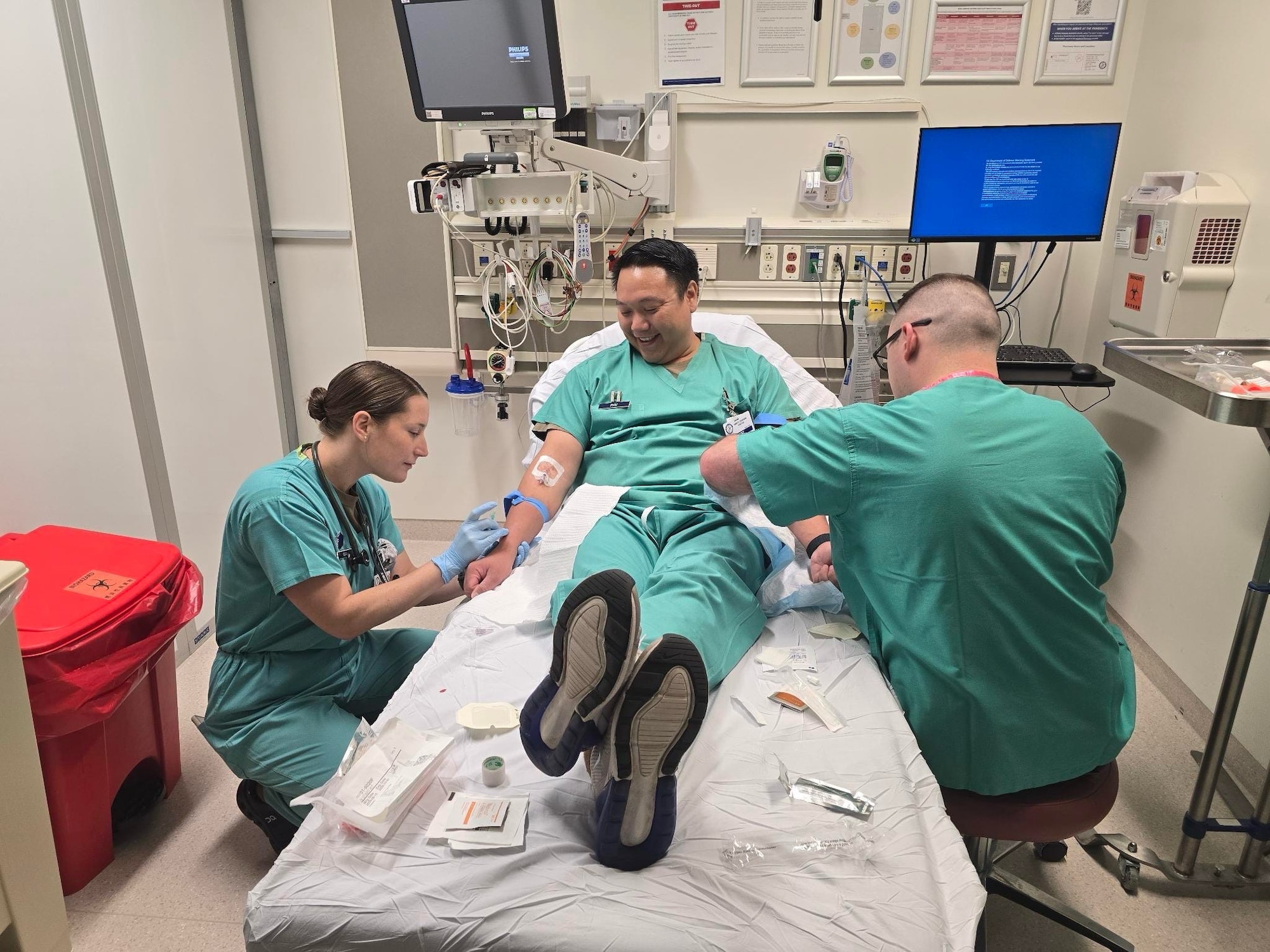 U.S. Air Force Master Sgt. Amanda Bean, Maj. Charlie Phu, and Staff Sgt. Connor Moore, all assigned to the 142nd Medical Group, practice intravenous insertion techniques during Medical Facility Annual Training (MFAT) at the U.S. Naval Hospital in Okinawa, Japan, July 13, 2025. The exercise enhanced joint interoperability and clinical readiness as part of a two-week mission supporting real-world patient care. (Courtesy photo)