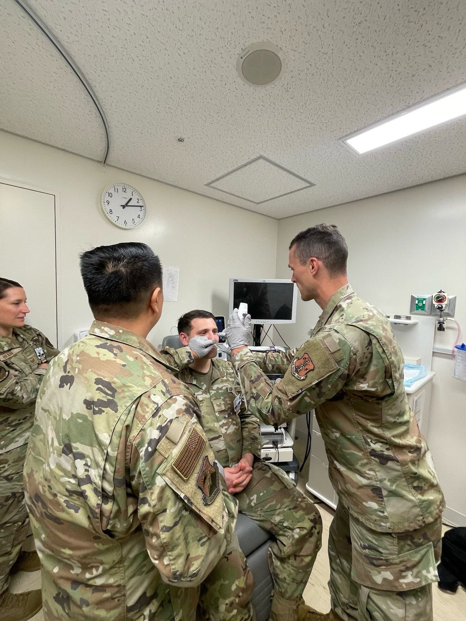 U.S. Air Force Lt. Col. Tim Aylward demonstrates nasal endoscopy procedures on Staff Sgt. Schyler Hollinger as Master Sgt. Amanda Bean and Maj. Charlie Phu observe during Medical Facility Annual Training (MFAT) at the U.S. Naval Hospital in Okinawa, Japan, July 13, 2025. The training fostered cross-specialty learning and supported the 142nd Medical Group’s clinical readiness in a joint-force setting. (Courtesy photo)