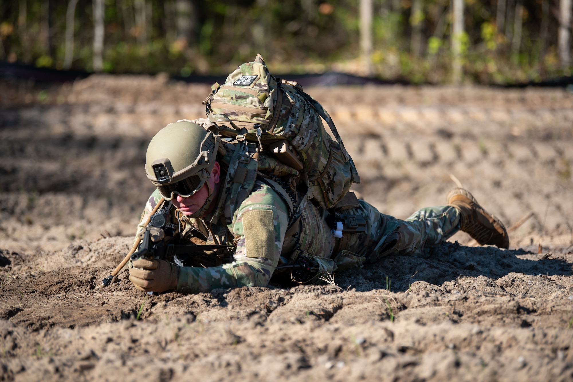 An Airman from the Kentucky Air National Guard’s 123rd Contingency Response Group lays prone to fortify a defensive position during an exercise at the Alpena Combat Readiness Training Center in Alpena, Mich., May 26, 2025. More than 50 Airmen from the Kentucky Air Guard, along with members of the Colorado Air National Guard’s 233rd  Security Forces Squadron and the Ecuadorian Air Force, participated in a nine-day field exercise here May 21 to 29. (U.S. Air National Guard photo by Phil Speck)