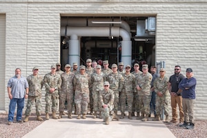 The 355th Civil Engineering Squadron Heating, Ventilation and Air Conditioning shop poses for a group photo at Davis-Monthan Air Force Base, Arizona, August 13, 2025. The HVAC team stood in front of a facility known as “The Beast” which powers over a quarter of the air conditioning throughout Davis-Monthan’s facilities. (U.S. Air Force photo by Airman Jaden Kidd)