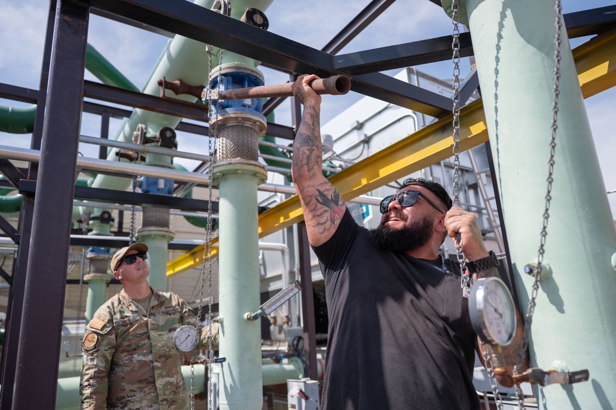 U.S. Air Force Staff Sgt. Dylan Davis, 355th Civil Engineer Squadron Heating, Ventilation and Air Conditioning noncommissioned officer in charge, left, and Steven Labrada, 355th CES HVAC Technician, perform maintenance on the facility known as “The Beast” at Davis-Monthan Air Force Base, Arizona, Aug. 13, 2025. Labrada is responsible for training new Airmen on HVAC operations. (U.S. Air Force photo by Airman Jaden Kidd)