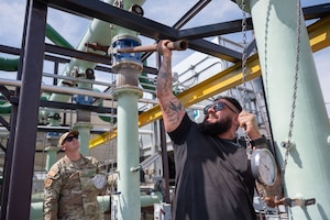 U.S. Air Force Staff Sgt. Dylan Davis, 355th Civil Engineer Squadron Heating, Ventilation and Air Conditioning noncommissioned officer in charge, left, and Steven Labrada, 355th CES HVAC Technician, perform maintenance on the facility known as “The Beast” at Davis-Monthan Air Force Base, Arizona, Aug. 13, 2025. Labrada is responsible for training new Airmen on HVAC operations. (U.S. Air Force photo by Airman Jaden Kidd)
