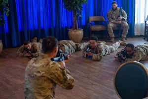 Airmen point training rifles at a simulated enemy target.