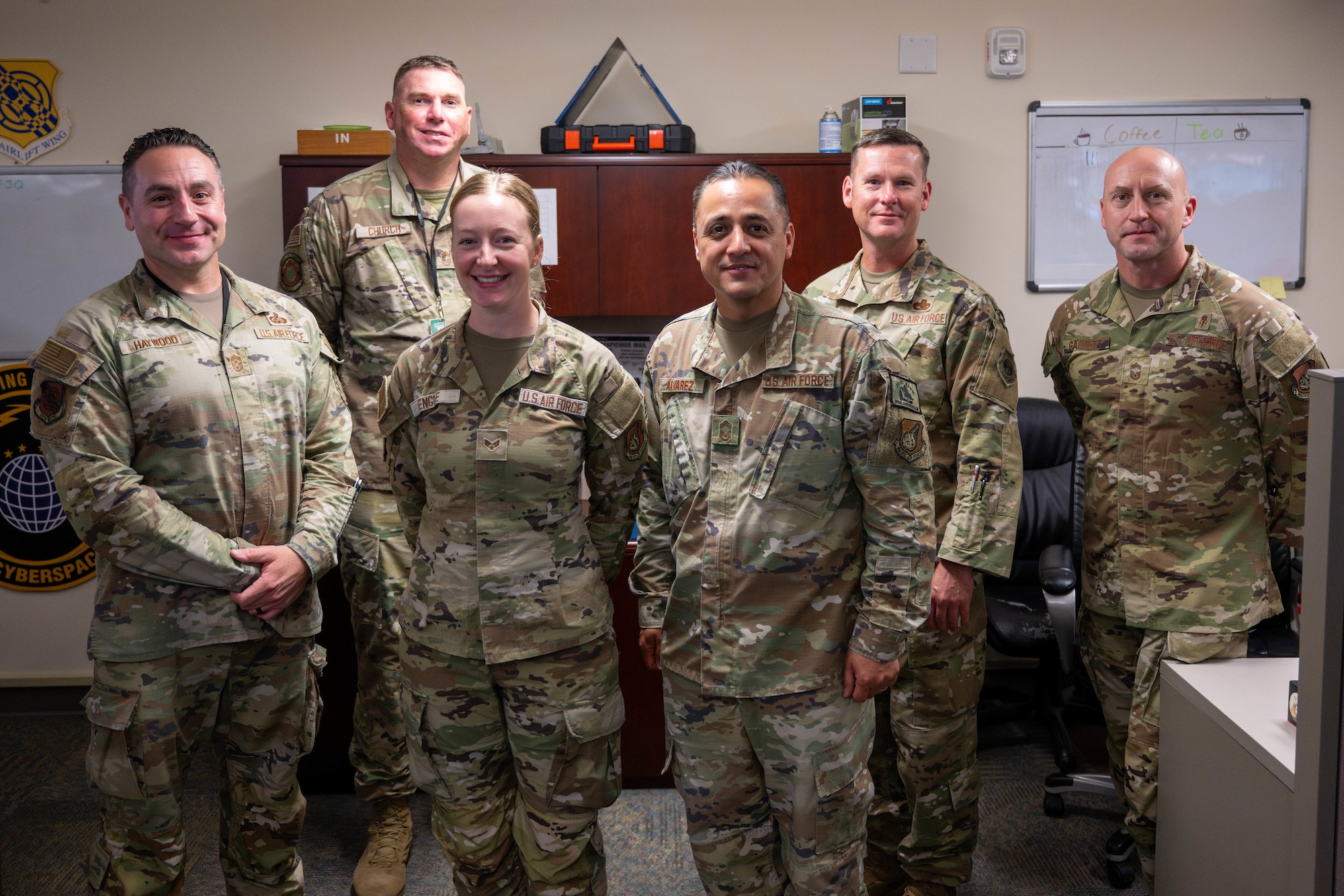 U.S. Air Force senior enlisted leaders pose for a photo after coining an Airman on Joint Base Pearl Harbor-Hickam, Hawaii.