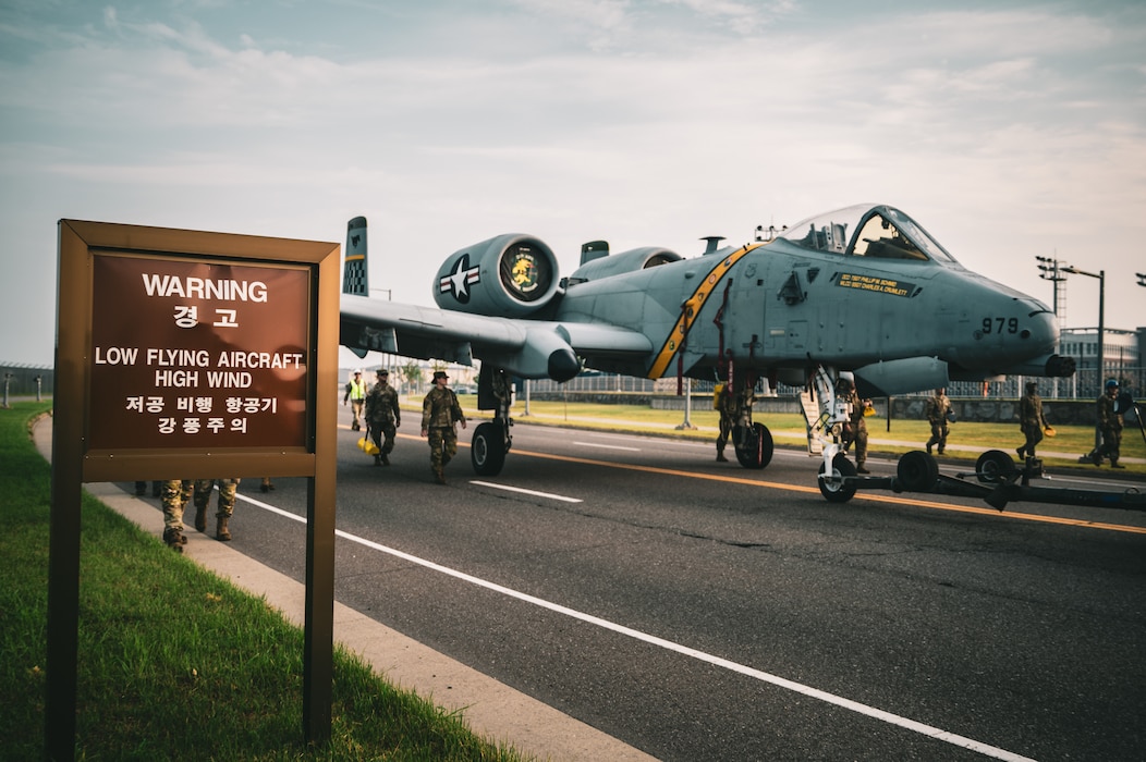 An A-10 Thunderbolt II aircraft gets towed down the road to be put on display at a traffic circle on Camp Humphreys, South Korea, August 2, 2025.