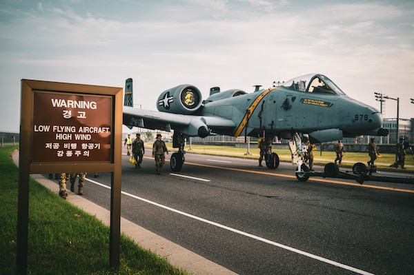 An A-10 Thunderbolt II aircraft gets towed down the road to be put on display at a traffic circle on Camp Humphreys, South Korea, August 2, 2025.