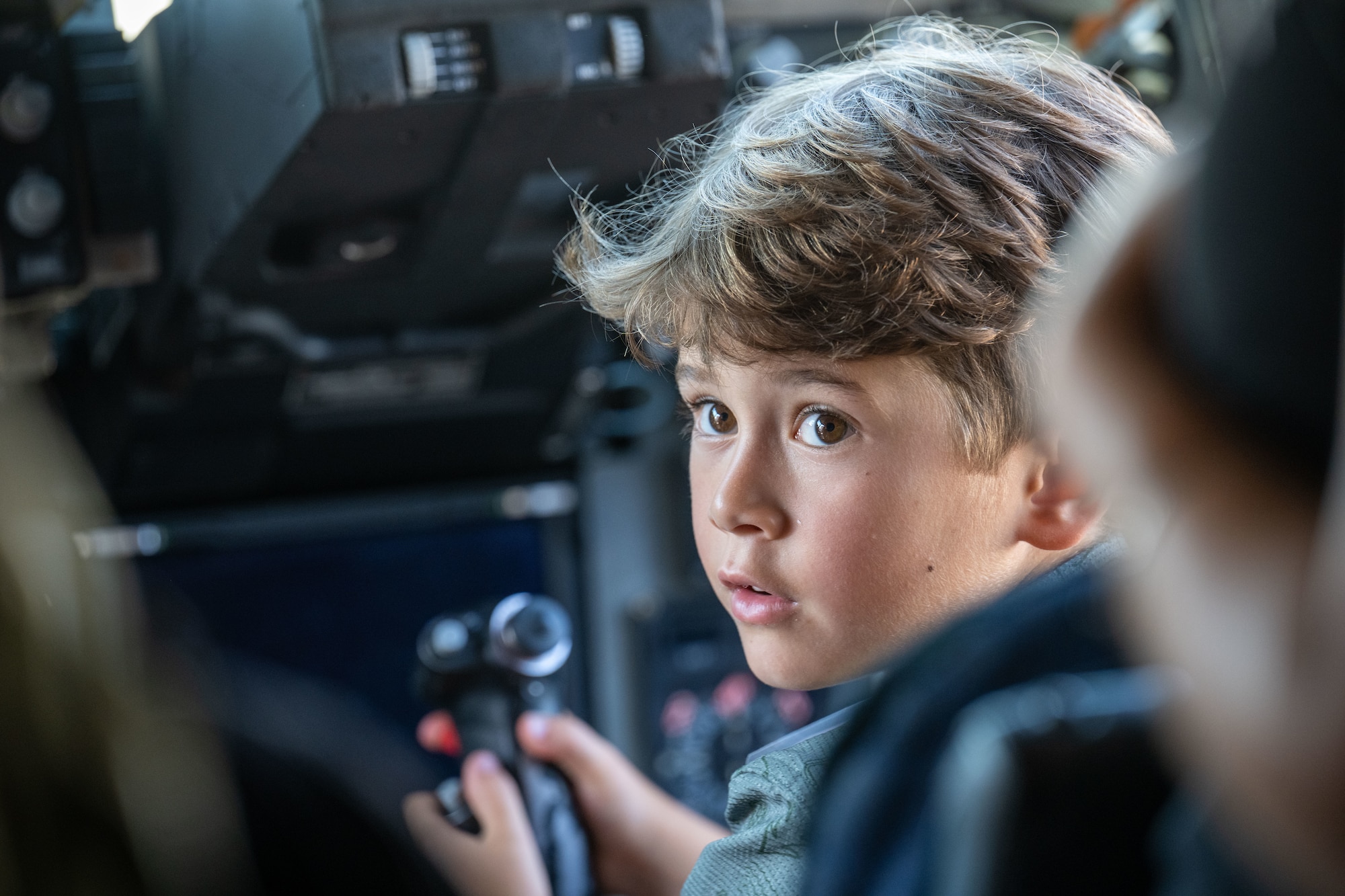 A Military child sits in the cockpit of a C-17 Globemaster from the 445th Air Lift Wing during the Kids Understanding Deployment Operations (KUDOS) event Aug. 8, 2025, at Wright-Patterson Air Force Base, Ohio. KUDOS teaches children about deployments through age-appropriate activities (U.S. Air Force photo by Jack Gardner)
