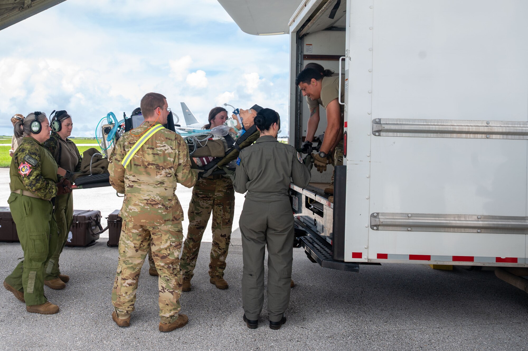 airmen load a stretcher onto a van