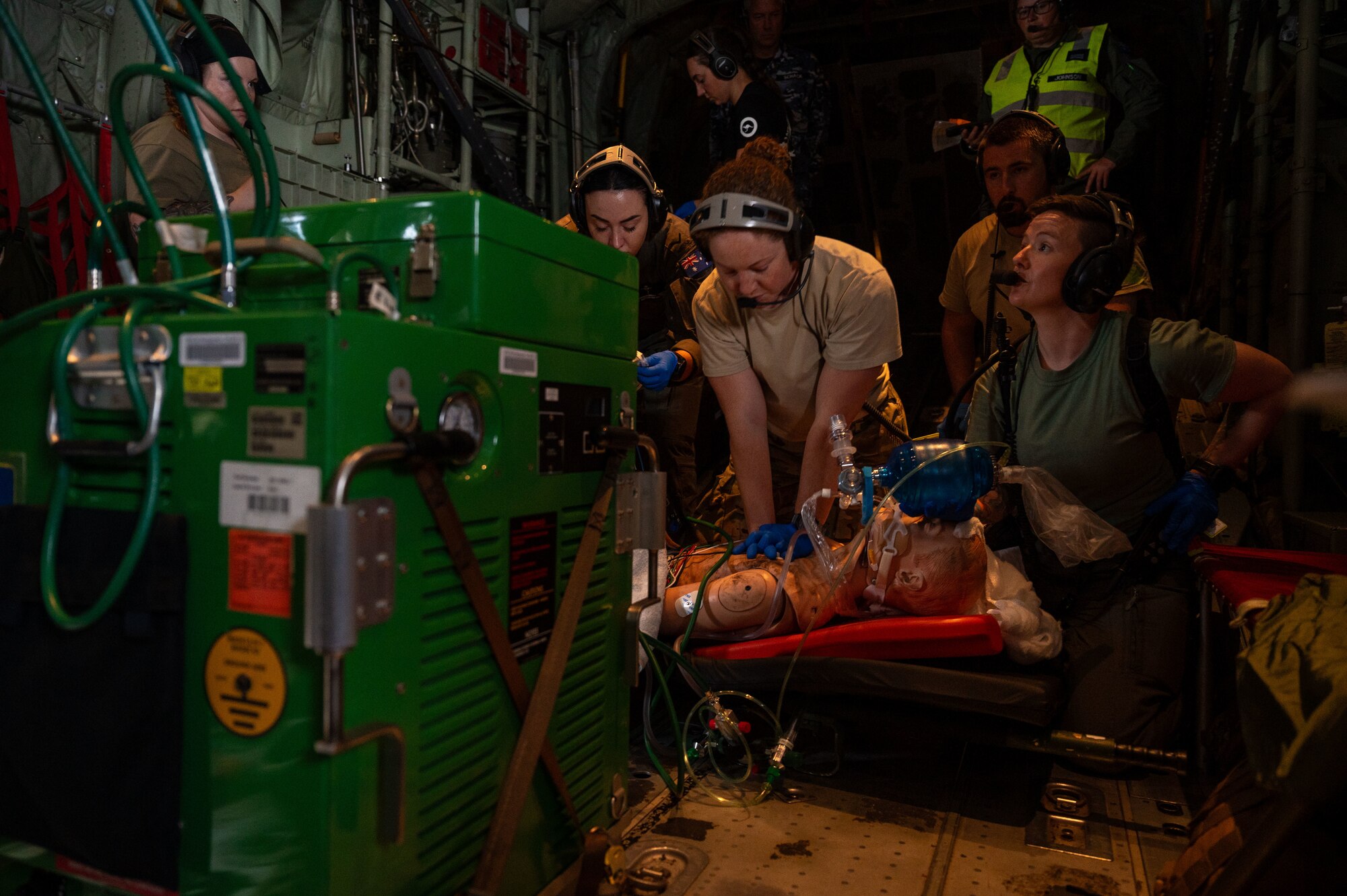 airmen provide patient care in the back of a C-130J Super Hercules