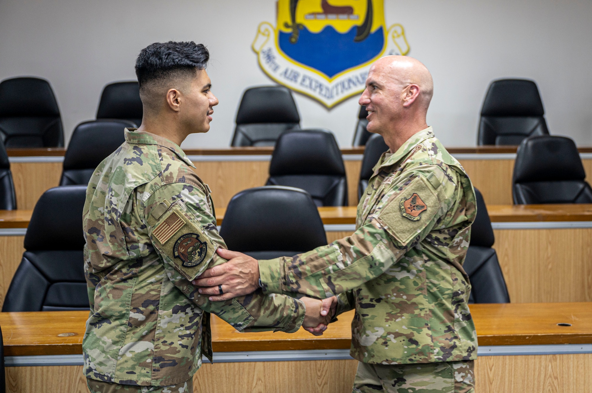 Chief Flosi right of frame shakes the hand of SrA Fernandez on the left of frame