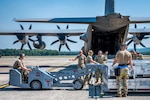 Crews from the 103d Airlift Wing and 104th Fighter Wing unload missile cases during a Distributed Integrated Combat Turn exercise at Westover Air Reserve Base, Massachusetts, July 24, 2025. The D-ICT provided simultaneous rearming and refueling of multiple fighter jets in under 90 minutes.