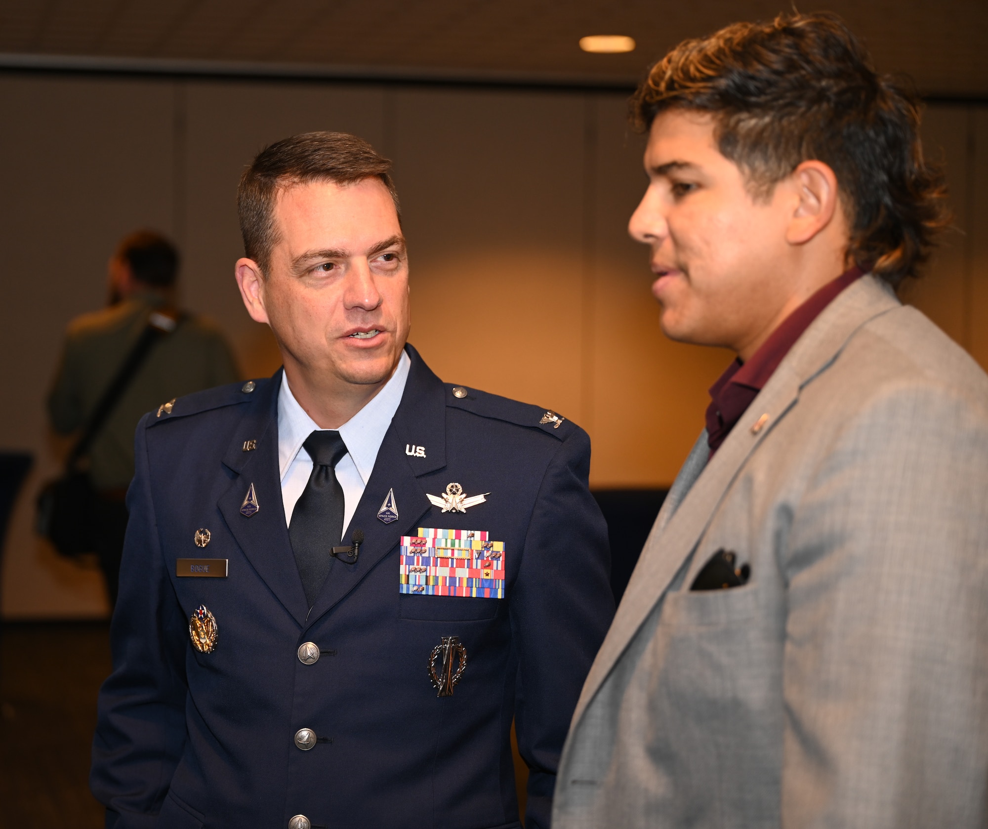 Col. Bogue stands to left of a guest during the State of the Bases event.