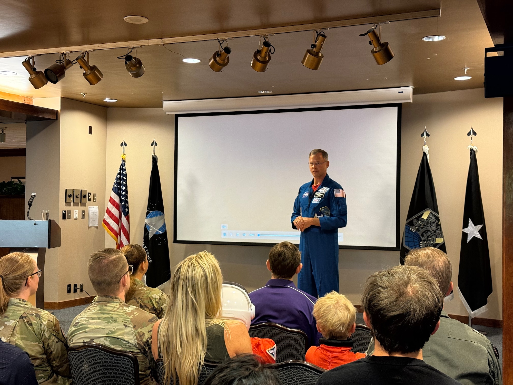 Astronaut stands in front of a group of people during a Q&A session.