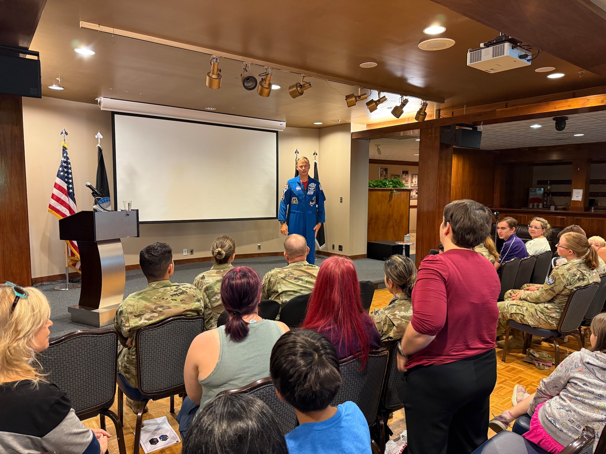 Astronaut stands in front of people during a Q&A session.