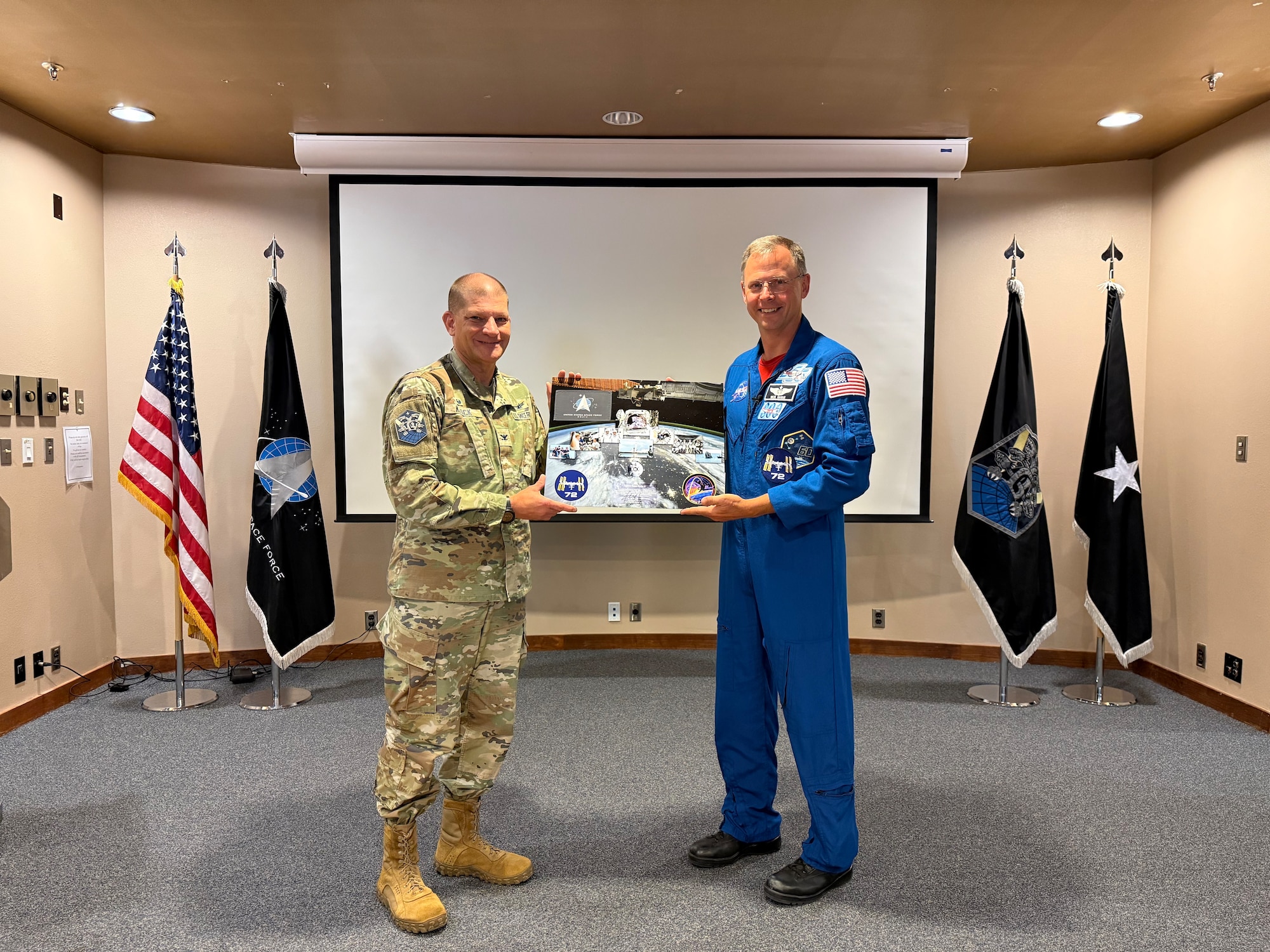 Two individuals pose for a photo holding a memento
