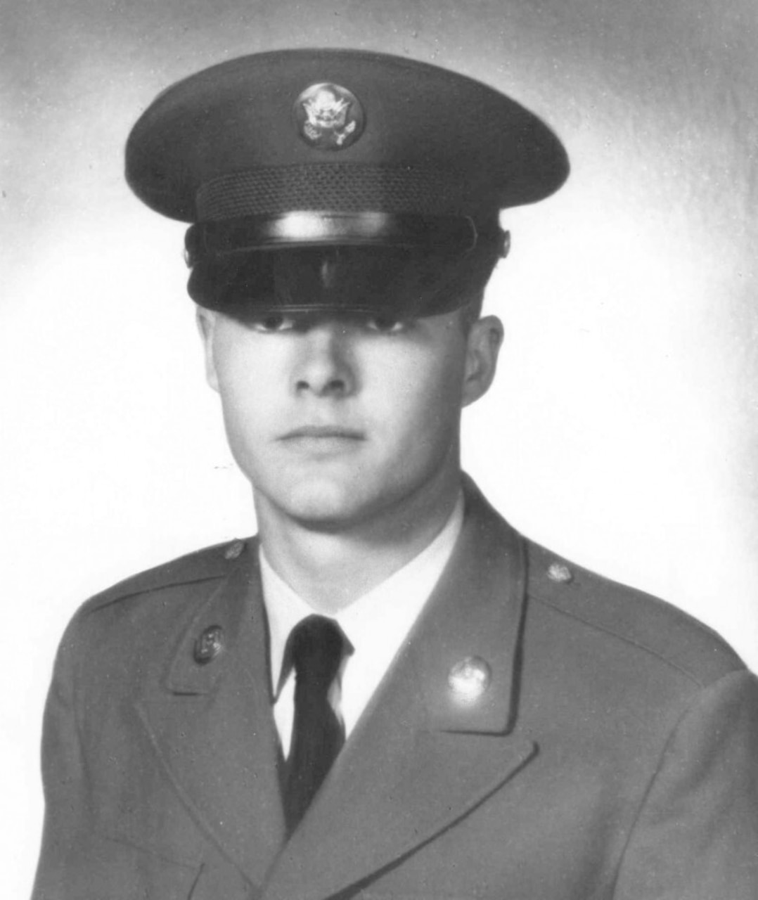 A man wearing a military uniform poses for a photo.