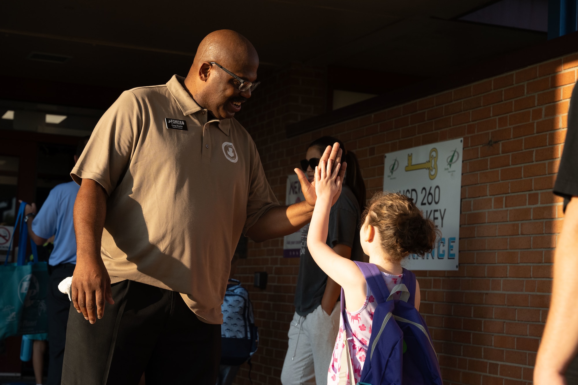 Greg Martin, 22nd Force Support Squadron school liaison, gives high fives at Wineteer Elementary, Wichita, Kansas, Aug. 13, 2025. The high fives and handshakes program is a volunteer-based program that allows Airmen to go to local schools to greet students as they start their day. (U.S. Air Force photo by Senior Airman Felicia Przydzial)