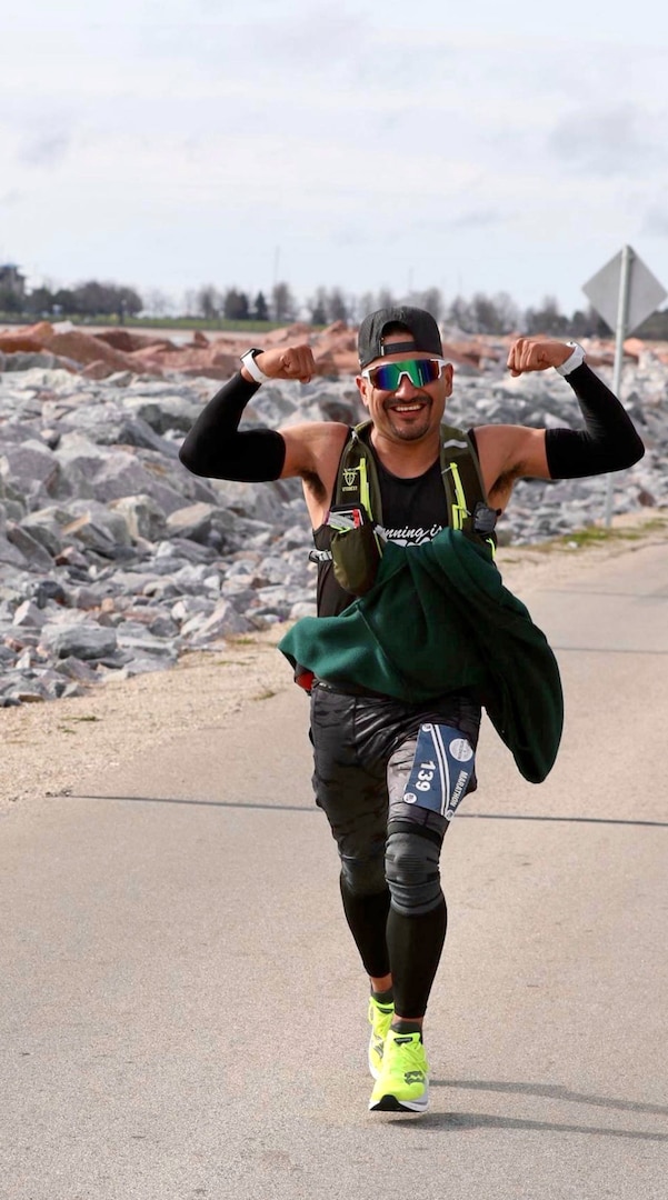 Posing for a photographer, Jesus Flores, USMEPCOM command paralegal, enjoys a scenic race. Flores, once 60 pounds heavier, now inspires others at USMEPCOM as a sharp-dressed ultra marathon runner.