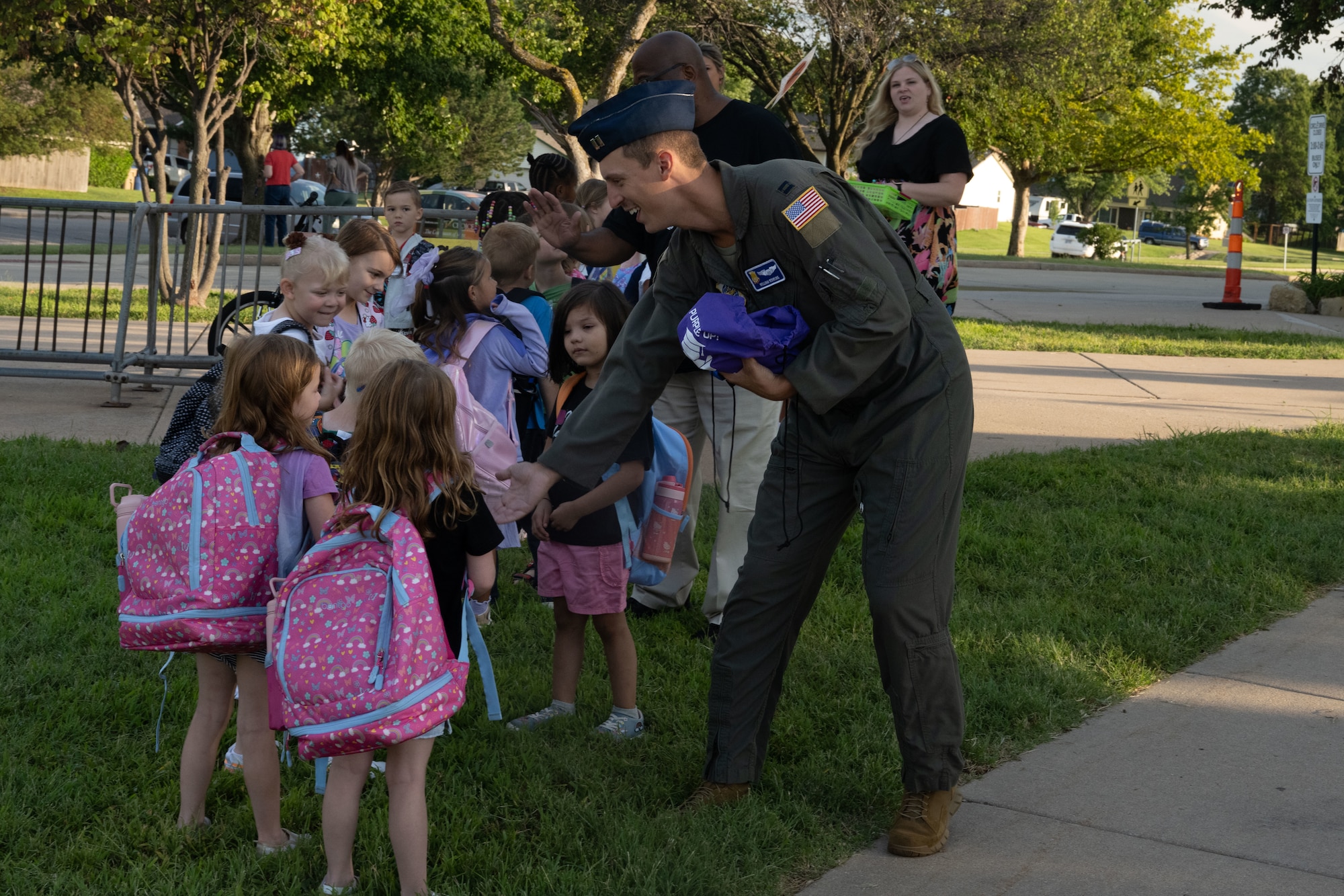 Capt. William Bowling, 350th Air Refueling Wing pilot, high fives students at Tanglewood Elementary School, Derby, Kansas, Aug. 14, 2025. The Fist Bumps and High Fives program is a volunteer-based program that allows Airmen to go to local schools to greet students as they start their day. (U.S. Air Force photo by Senior Airman Felicia Przydzial)
