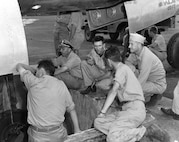 TINIAN, Northern Mariana Islands – Navy Capt. William “Deak” Parsons (right) supervises loading the “Little Boy” bomb aboard the B-29 “Enola Gay.” Norman Ramsey is on his left, with his back to the camera. Ramsey is the scientist who supervised the team designing bomb casings and testing scale models.