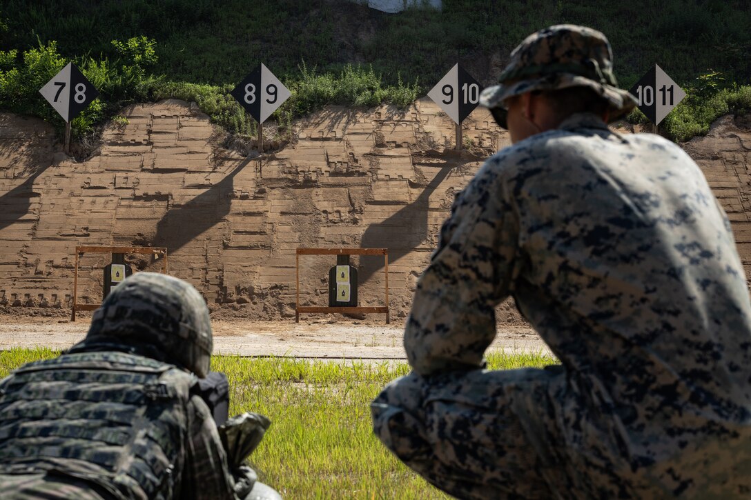 A Republic of Korean Marine, left, fires at a target at a battle sight zero range during the Korean Marine Exchange Program 25.2 in Pocheon, South Korea, July 26, 2025. KMEP is conducted regularly between the ROK and U.S. Marine Corps to increase their combined capabilities through realistic training geared towards deterrence and maintaining peace in the Indo-Pacific. (U.S. Marine Corps photo by Lance Cpl. Van Hoang)