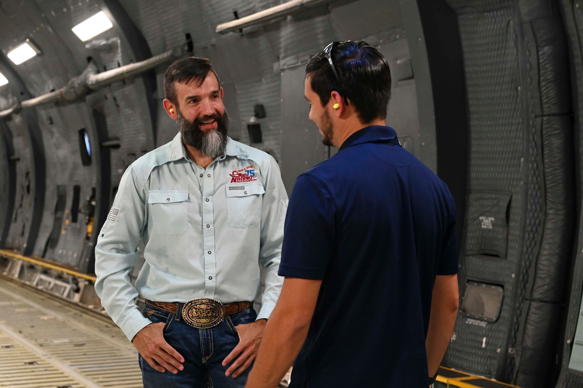 Chris Weaver, FBI San Antonio Citizens Academy participant, discusses the 433rd Airlift Wing mission and C-5M Super Galaxy capabilities with a member of the 433rd Airlift Wing Public Affairs team during a tour at Joint Base San Antonio-Lackland, Texas, Aug. 5, 2025.