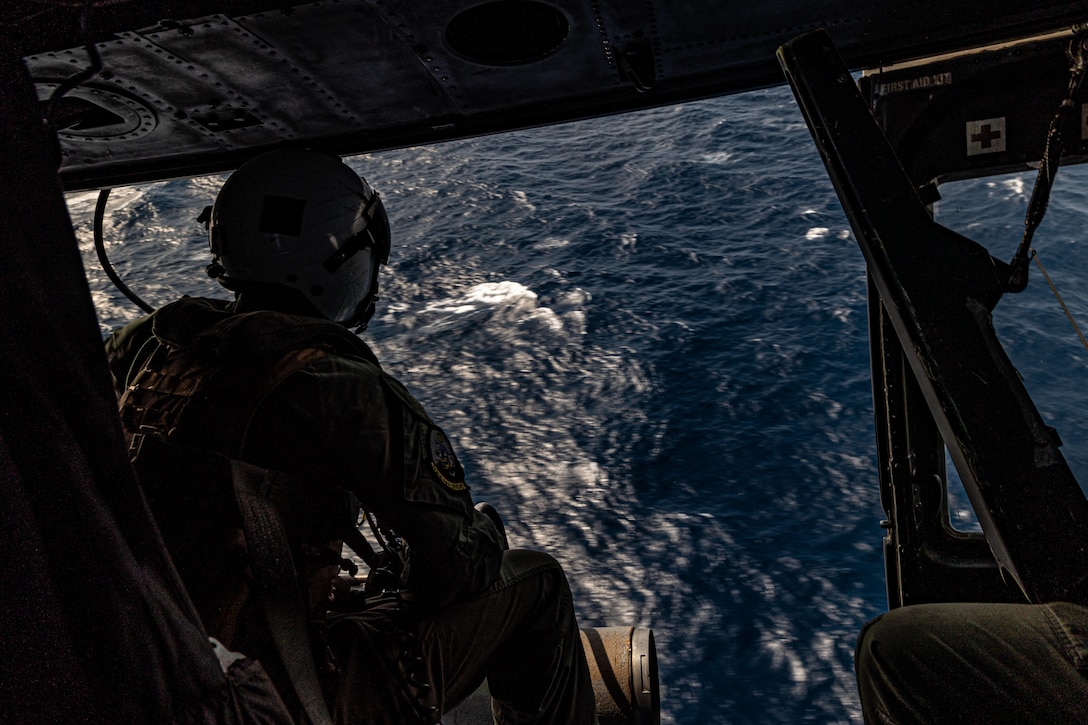 U.S. Marine Corps Cpl. Ryan Hicks, a helicopter crew chief with Marine Medium Tiltrotor Squadron 263 (Reinforced), 22nd Marine Expeditionary Unit (Special Operations Capable), searches for enemy forces in the operating aboard a UH-1Y Venom helicopter from the U.S. Navy Wasp-class amphibious assault ship USS Iwo Jima (LHD 7), during a live-fire exercise in support of Composite Training Unit Exercise while underway in the Atlantic Ocean, July 5, 2025. During COMPTUEX, the IWO ARG and 22nd MEU(SOC), refine tactics, techniques, and procedures to execute warfighting functions that enhance operational readiness and lethality as a unified IWOARG/22 MEU(SOC) team. (U.S. Marine Corps photo by Cpl. Emily Hazelbaker)
