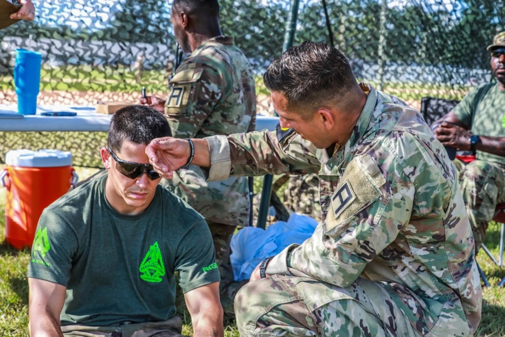 Capt. Jarrod Howell and Sgt. 1st Class Mk-Ada-Quet Generaux, both Observer Coach Trainers with 4th Cavalry Brigade, Division East, First Army out of Fort Knox, Kentucky, treat a simulated heat casualty during the Safety Lane; Evaluate a Casualty for a Heat Injury portion of the Donovan Field Lane Warrior Task and Drills Proficiency Assessment of the first-ever United States Army John J. Pershing Best Observer Coach/Trainer Competition at Fort Stewart, Georgia Aug. 28, 2024. The event brings professionals from across the U.S. Army to compete for the honor of Best OC/T from August 27-29.