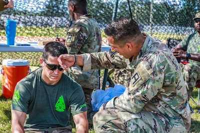 Capt. Jarrod Howell and Sgt. 1st Class Mk-Ada-Quet Generaux, both Observer Coach Trainers with 4th Cavalry Brigade, Division East, First Army out of Fort Knox, Kentucky, treat a simulated heat casualty during the Safety Lane; Evaluate a Casualty for a Heat Injury portion of the Donovan Field Lane Warrior Task and Drills Proficiency Assessment of the first-ever United States Army John J. Pershing Best Observer Coach/Trainer Competition at Fort Stewart, Georgia Aug. 28, 2024. The event brings professionals from across the U.S. Army to compete for the honor of Best OC/T from August 27-29.