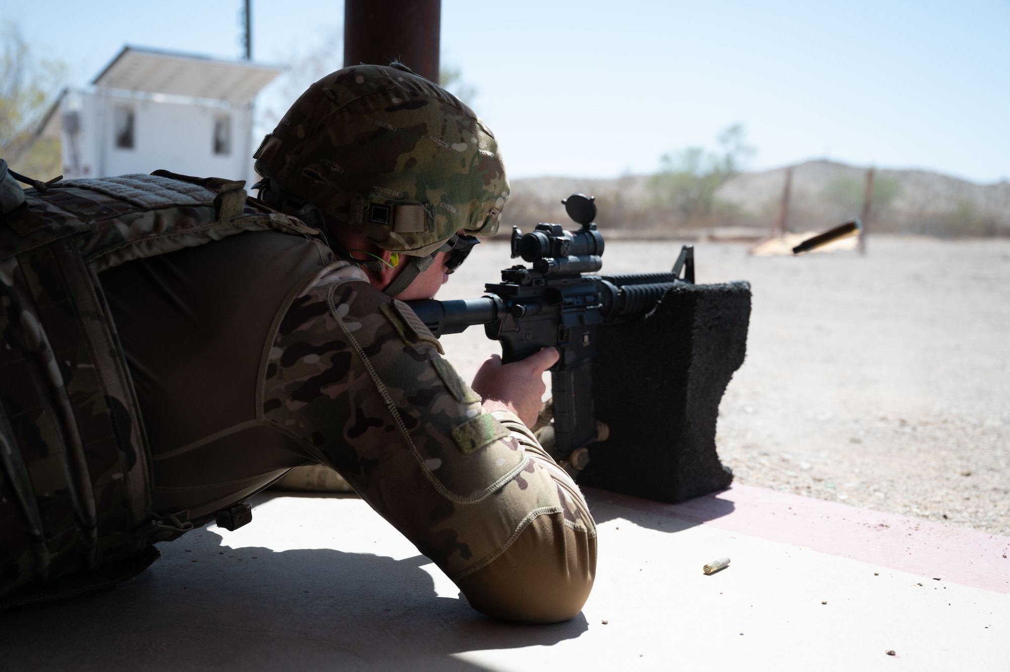 U.S. Air Force Airman 1st Class Ryan Armstrong, 55th Rescue Squadron special missions aviator, shoots at targets in the prone position during the German Armed Forces Schützenschnur event at Gila Bend, Arizona, August 8, 2025. Airmen were tasked with shooting the targets in different positions while performing burpees in between. (U.S. Air Force photo by Airman Jaden Kidd)