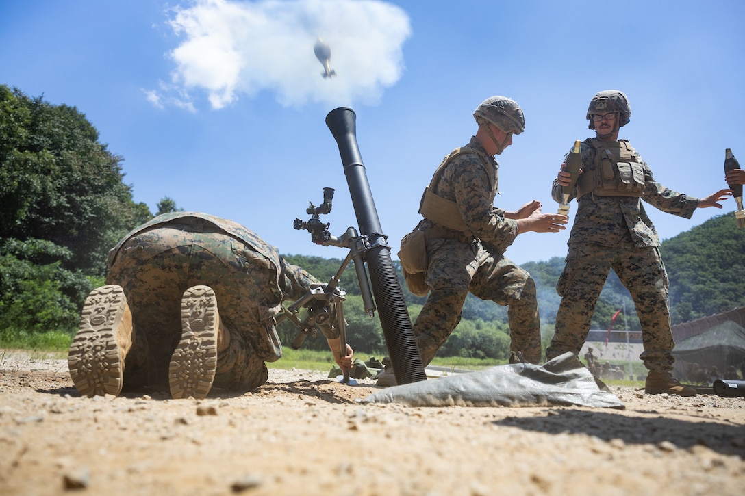U.S. Marine Corps Cpl. Paul Bax, center, a mortarman with 2nd Battalion, 23rd Marines, forward deployed with 4th Marine Regiment, 3d Marine Division as part of the Unit Deployment Program, fires an 81mm mortar round during the Korean Marine Exercise Program 25.2 in Pocheon, South Korea, July 28, 2025. KMEP is conducted regularly between the ROK and U.S. Marine Corps to increase their combined capabilities through realistic training geared towards deterrence and maintaining peace in the Indo-Pacific. (U.S. Marine Corps photo by Lance Cpl. Van Hoang)