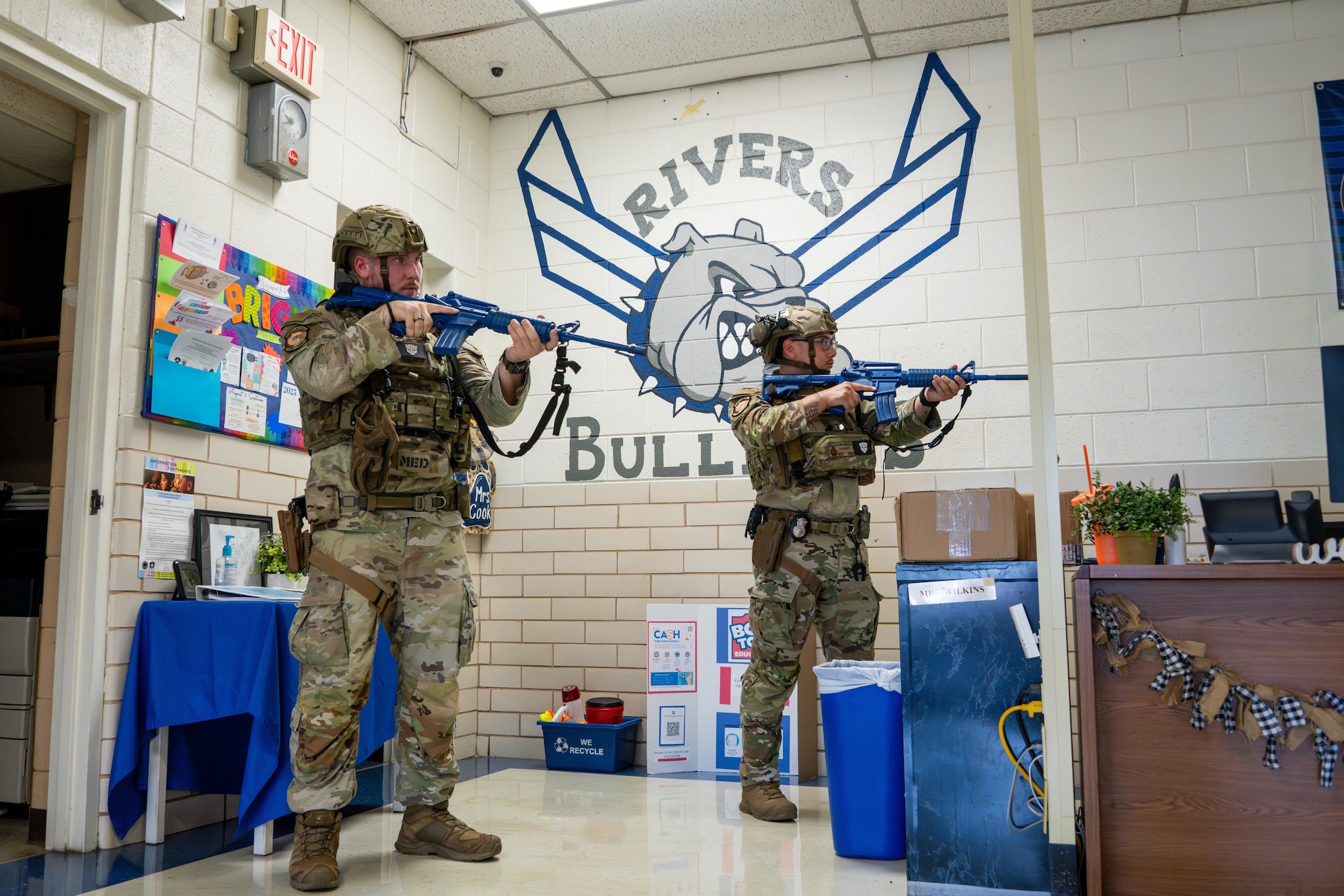 U.S. Air Force Senior Airman Seth Chaffee, left, 97th Security Forces Squadron (SFS) base defense operation center controller, and Senior Airman Nathan Gonzalez, right, 97th SFS patrolman, stand ready during an active shooter exercise at L. Mendel Rivers Elementary School at Altus Air Force Base, Oklahoma, Aug. 12, 2025. This exercise is performed yearly to strengthen the installation’s ability to protect its Airmen, families, and mission. (U.S. Air Force photo by Airman 1st Class Lauren Torres)