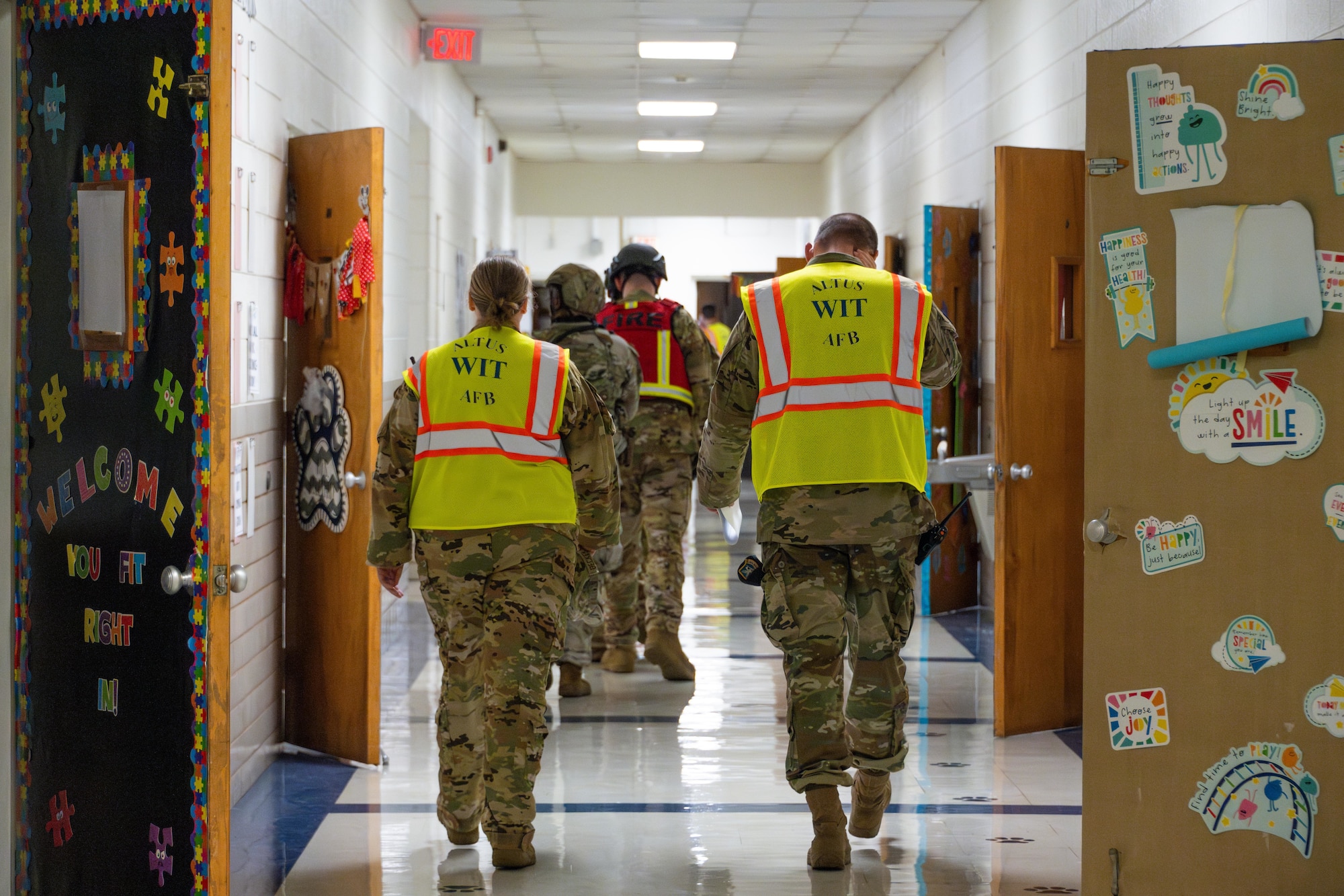 U.S. Air Force Tech. Sgt. Emily Beckerjeck, left, 97th Civil Engineer Squadron non-commissioned officer in charge of logistics, and Tech. Sgt. Caleb Whitworth, right, 97th Security Forces Squadron non-commissioned officer in charge of standardization and evaluation, walk toward other Airmen to evaluate their performance during an active shooter exercise at L. Mendel Rivers Elementary School at Altus Air Force Base, Oklahoma, Aug. 12, 2025. Their assessments helped identify strengths and areas for improvement to enhance overall readiness. (U.S. Air Force photo by Airman 1st Class Lauren Torres)