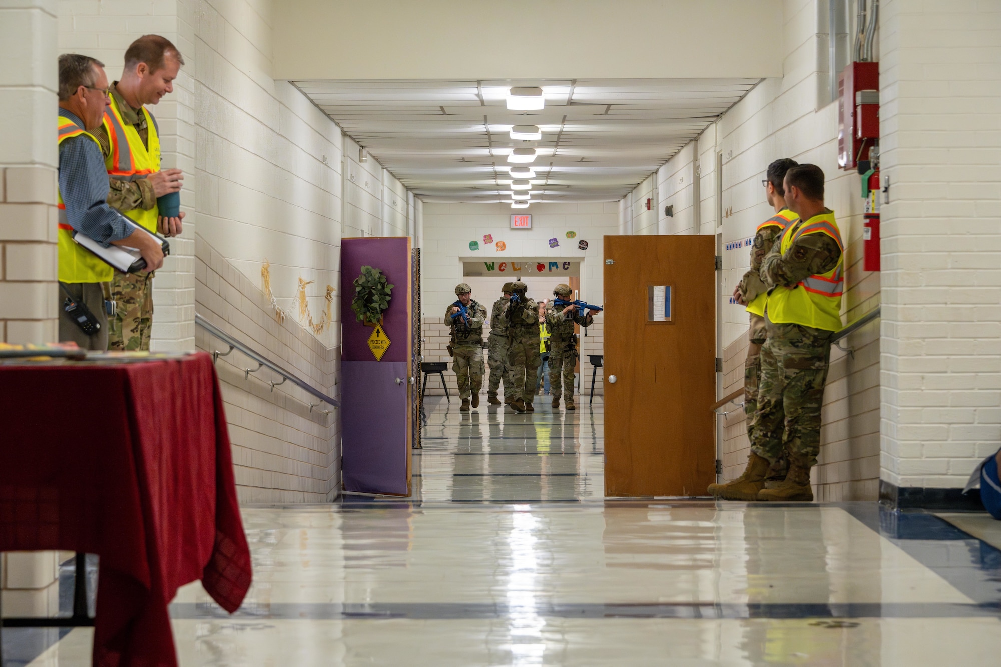 Airmen assigned to the 97th Security Forces Squadron swiftly walk in formation during an active shooter exercise at L. Mendel Rivers Elementary School at Altus Air Force Base, Oklahoma, Aug. 12, 2025. Every movement was coordinated to mirror real-world situations they could face, all under the watchful eyes of evaluators, ensuring the highest standards of readiness. (U.S. Air Force photo by Airman 1st Class Lauren Torres)