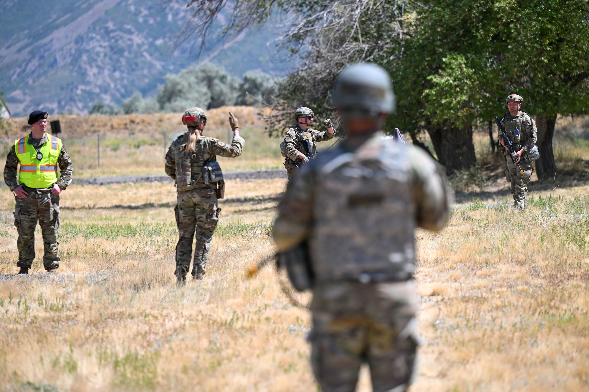 Airmen use hand signals while patrolling during a deployment readiness exercise