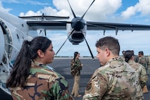 A 492nd Special Operations Wing Special Operations Advisor Team member, right, speaks with a role player, left, about the capabilities of a C-146 Wolfhound