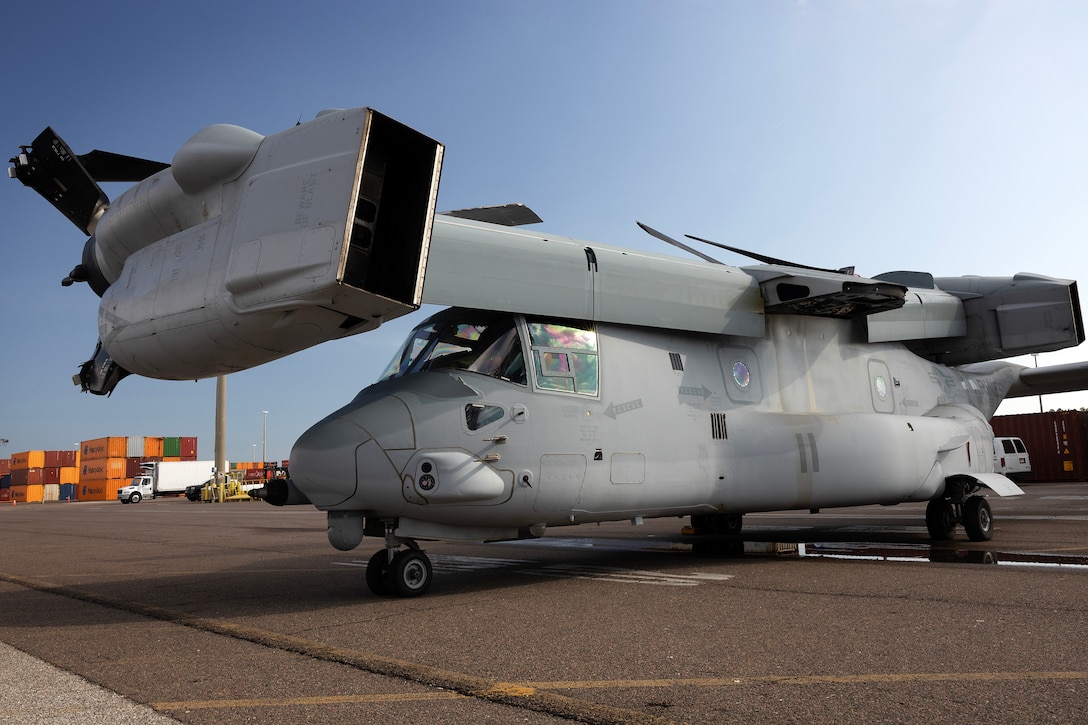 An MV-22 Osprey rests in position for loading aboard a contracted vessel Aug. 15, 2025, at Dames Point Marine Terminal in Jacksonville, Florida. Blount Island Command provided tow tractors and other prepositioned equipment to support Marine Medium Tiltrotor Squadron 162 (Reinforced) as part of regional responsiveness efforts in the U.S. Marine Corps Forces Europe and Africa area of responsibility. (Official Marine Corps Photo/Dustin Senger)