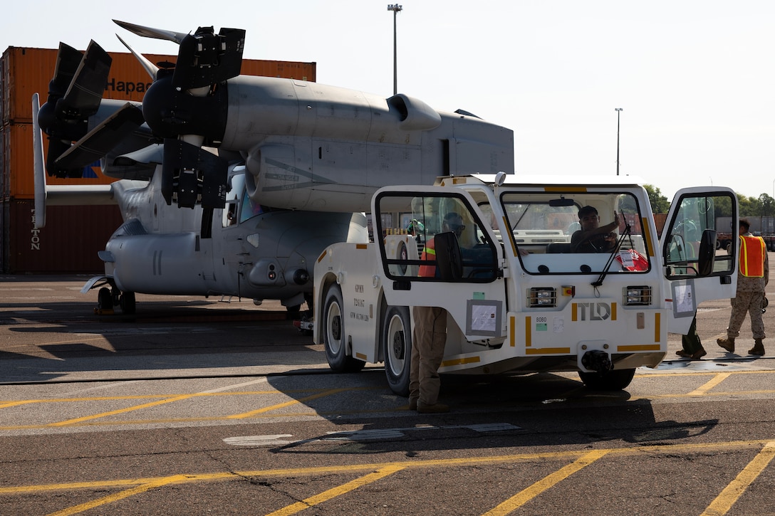 U.S. Marines maneuver an MV-22 Osprey into position for loading aboard a contracted vessel Aug. 15, 2025, at Dames Point Marine Terminal in Jacksonville, Florida. Blount Island Command provided tow tractors and other prepositioned equipment to support Marine Medium Tiltrotor Squadron 162 (Reinforced) as part of regional responsiveness efforts in the U.S. Marine Corps Forces Europe and Africa area of responsibility. (Official Marine Corps Photo/Dustin Senger)