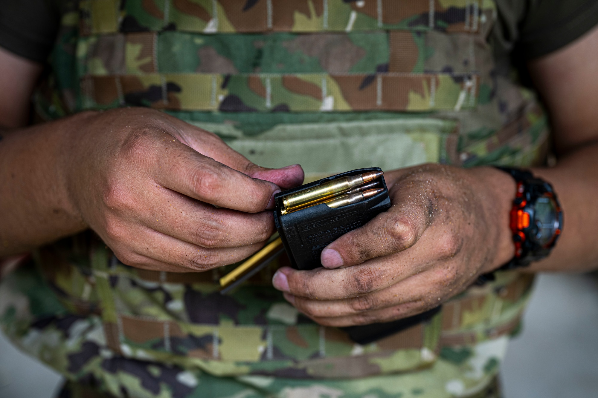 An Airman is loading a magazine.