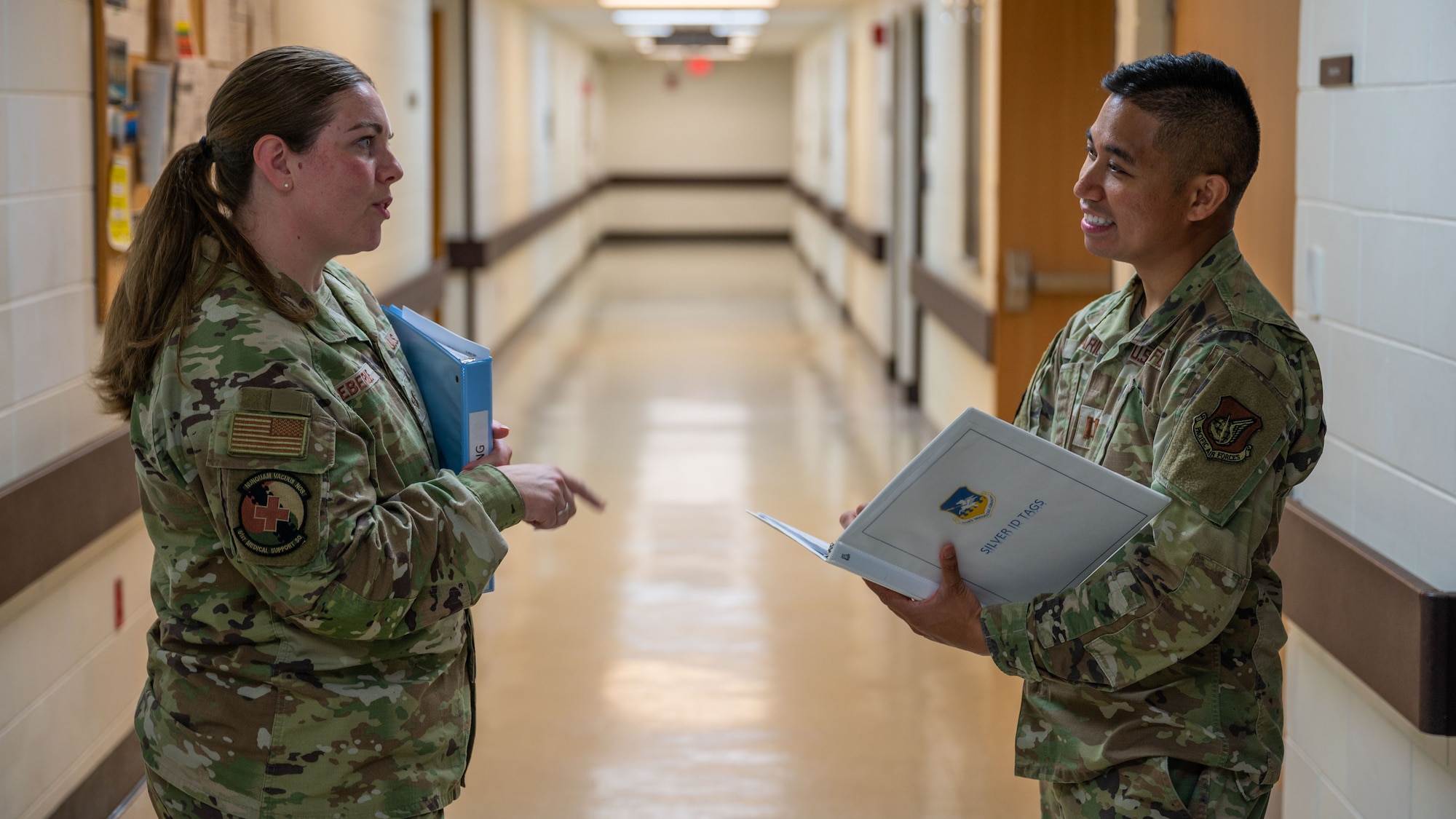 U.S. Air Force Tech. Sgt. Kylie Eberle, left, 51st Medical Support Squadron medical readiness noncommissioned officer in charge, speaks with Capt. Julian Belisario, 51st Medical Group clinical nurse, at Osan Air Base, Republic of Korea, Aug. 13, 2025.