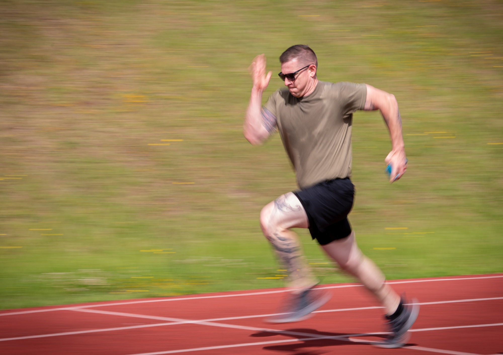 Tech. Sgt. Michael Howell, fire crew chief for the Kentucky Air National Guard's 123rd Civil Engineer Squadron, sprints at full force during his final lap around the track at Lajes Field, Azores, June 23, 2025, as part of a physical fitness event. Howell was at Lajes for a two-week field training deployment. (U.S. Air National Guard photo by Airman 1st Class Angelee Barnett)