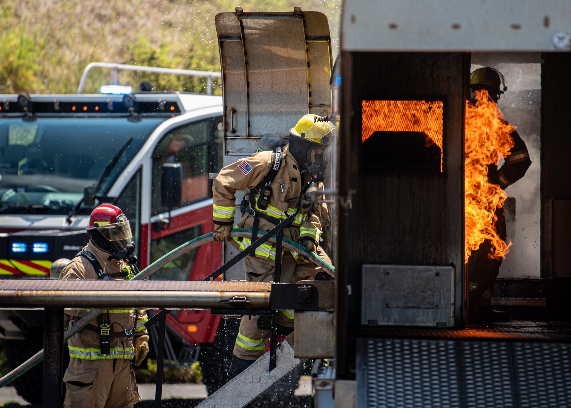Fire protection specialists from the Kentucky Air National Guard’s 123rd Civil Engineer Squadron extinguish flames in the interior of a mock aircraft during an exercise at Lajes Field, Azores, June 23, 2025. The exercise was staged by the Portuguese military to help prepare Guardsmen for fire crisis scenarios. (U.S. Air National Guard photo by Airman 1st Class Angelee Barnett)