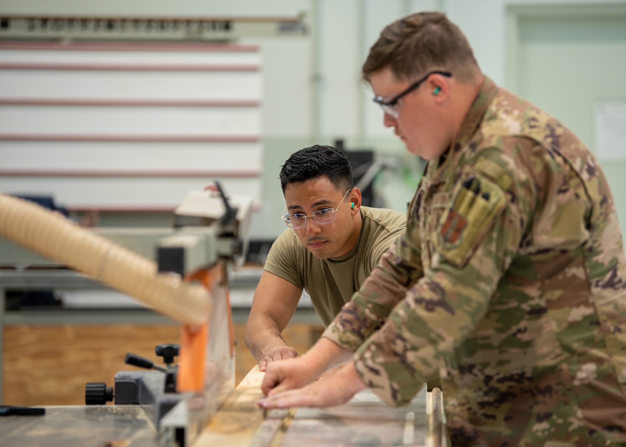 Senior Airman Elmer Lopez-Duran, left, a structures specialist from the Kentucky Air National Guard’s 123rd Civil Engineer Squadron, cuts wood used to repair door jambs at Lajes Field, Azores, June 24, 2025. Airmen from the unit were tasked with base rejuvenation efforts across Lajes Field during a two-week deployment. (U.S. Air Force photo by Airman 1st Class Angelee Barnett)
