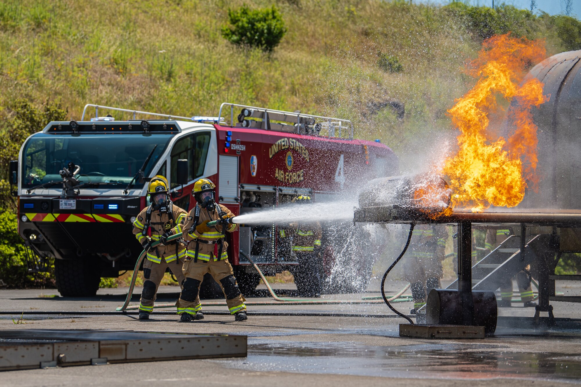 Fire protection specialists from the Kentucky Air National Guard’s 123rd Civil Engineer Squadron extinguish flames from a simulated engine burn during an exercise at Lajes Field, Azores, June 23, 2025. The exercise was staged by the Portuguese military to help prepare Guardsmen for fire crisis scenarios. (U.S. Air National Guard photo by Airman 1st Class Angelee Barnett)