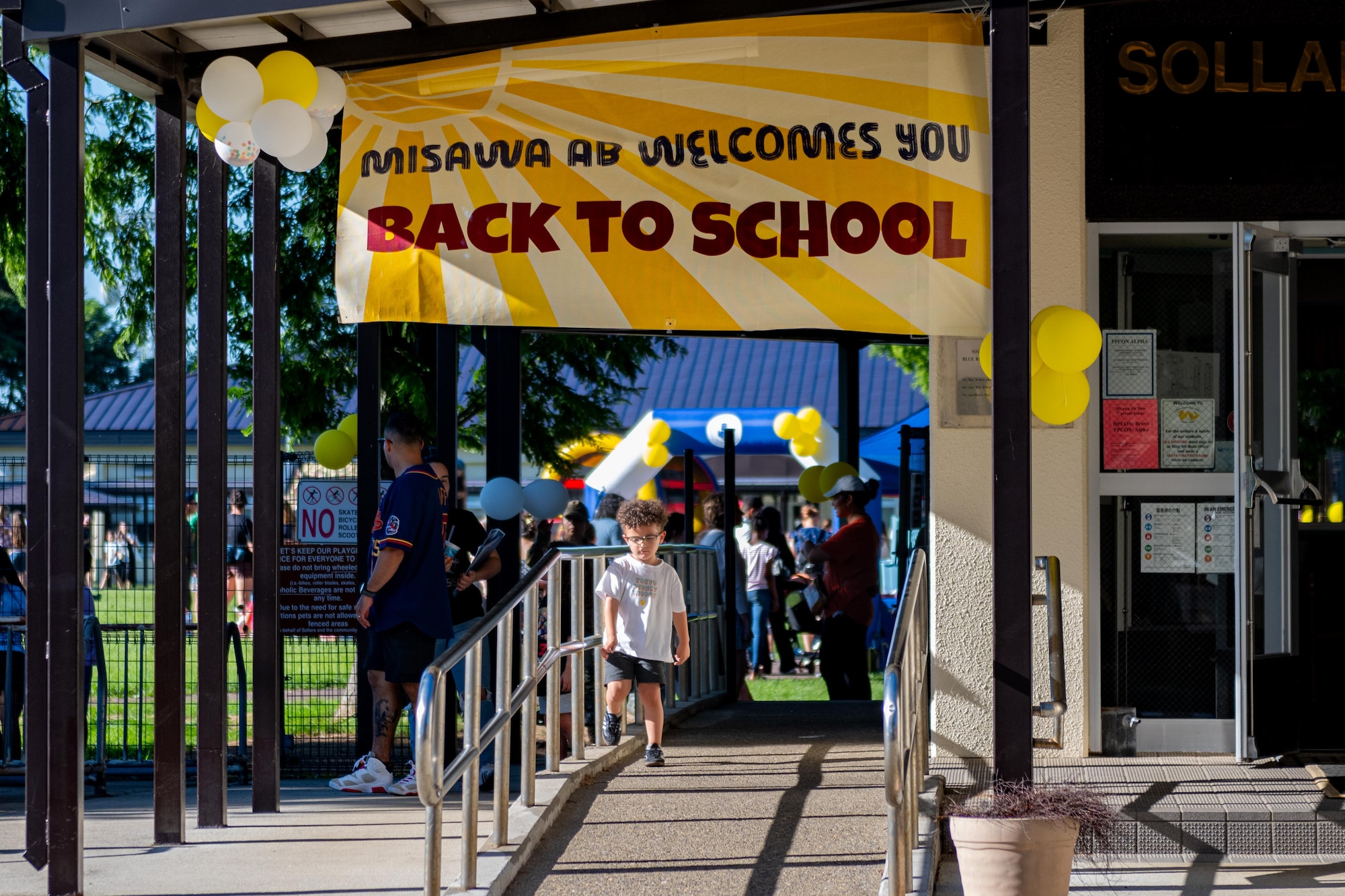 A child walks under a “back to school” sign.
