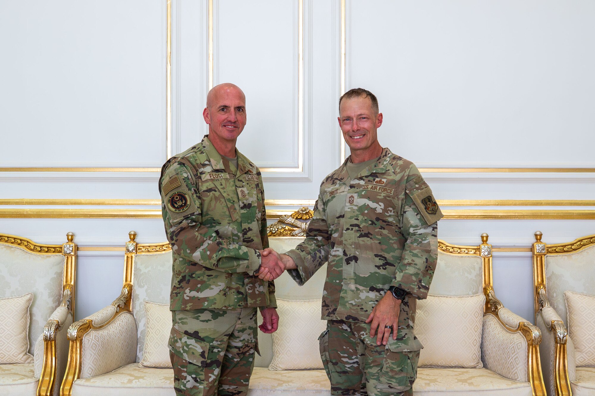 Two men shake hands.