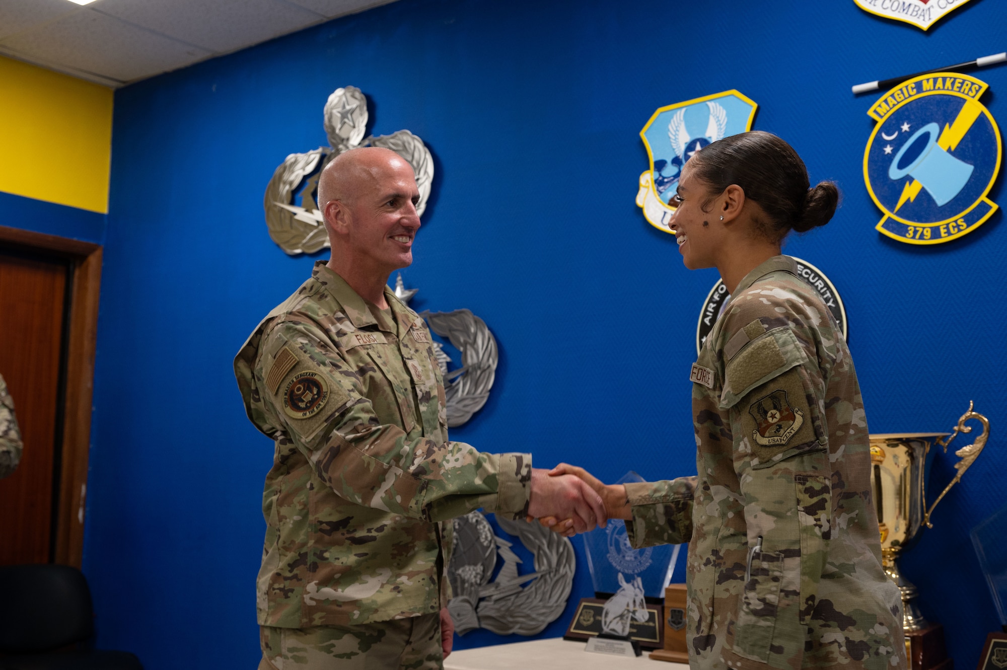 Chief Master Sgt. of the Air Force David Flosi coins Senior Airman Odessa Vanzelf 379th Air Expeditionary Wing religious affairs airman, during a visit within the U.S. Central Command area of responsibility, Aug. 12, 2025. Vanzelf was one of several Airmen recognized for their contributions to the 379th Air Expeditionary Wing mission to generate combat airpower. (U.S. Air Force photo by Dieondiere Jefferies)