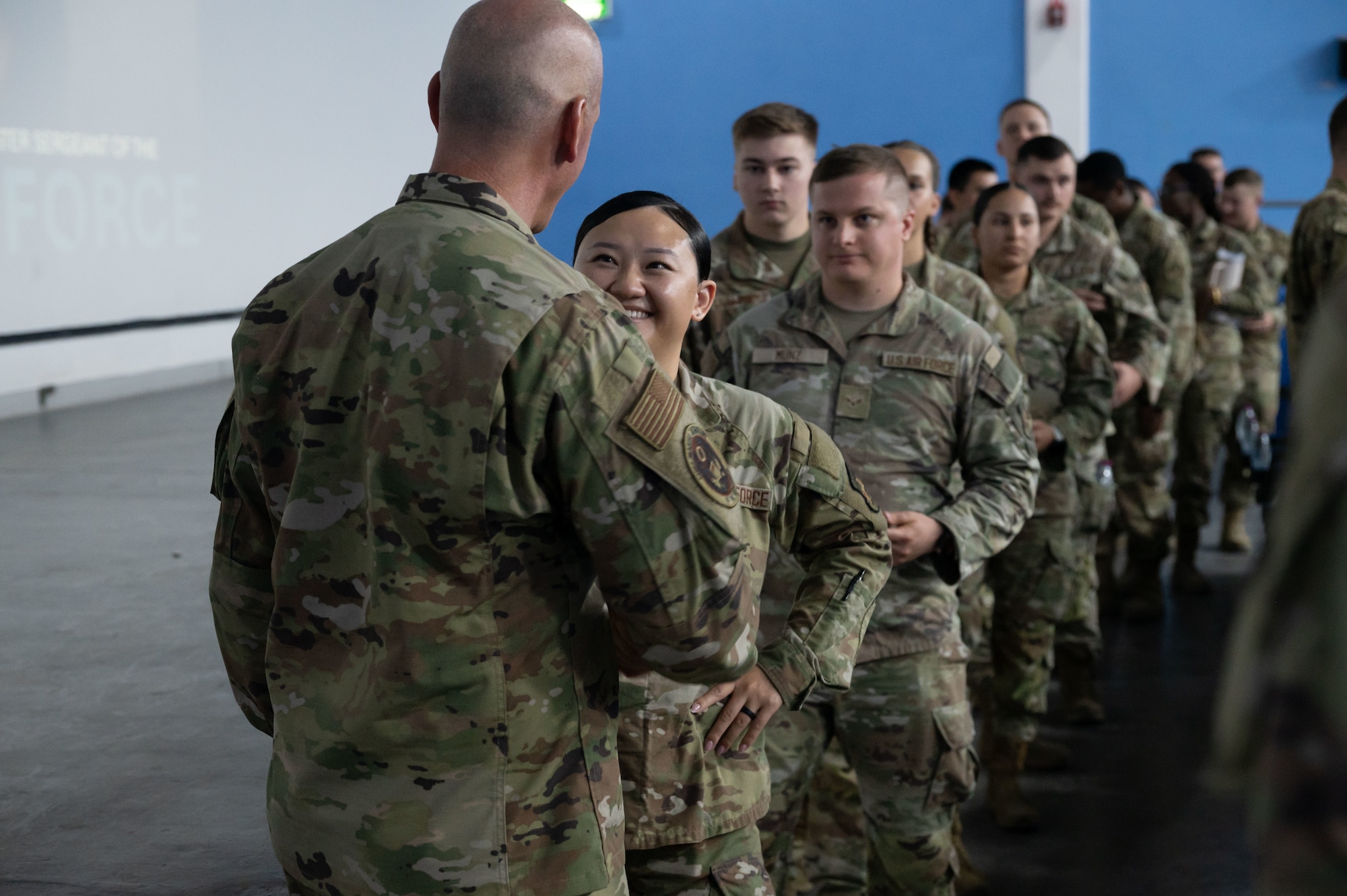 Chief Master Sgt. of the Air Force David Flosi greets an Airman, during a visit within the U.S. Central Command area of responsibility, Aug. 12, 2025. During the address, Flosi highlighted topics including force readiness, resiliency and the strategic role the 379th AEW plays in regional operations.(U.S. Air Force photo by Dieondiere Jefferies)